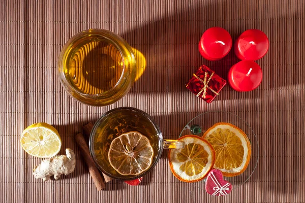 Ginger tea with spices, honey, cinnamon, lemon and dried fruit on a linen background — Stock Photo, Image