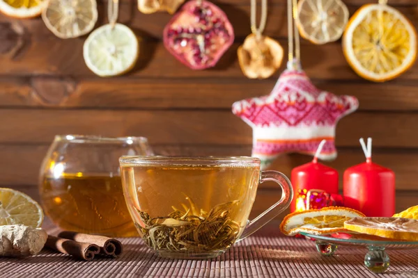 Имбирный чай со специями, медом, корицей, лимоном и сухофруктами на льняном фоне — стоковое фото