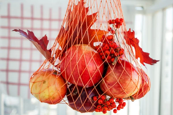 Red ripe apples in a string bag mesh — Stock Photo, Image