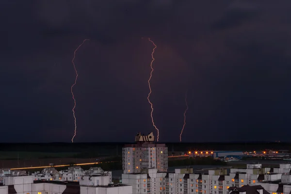 Éclair dans le ciel nocturne sur les maisons de la ville — Photo