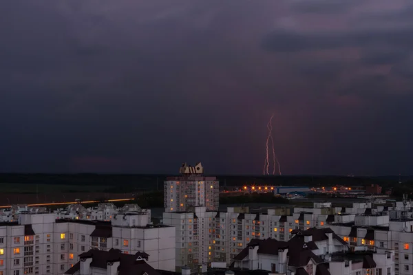 Lightning på natthimlen över staden hus Stockbild