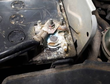 Oksitlenmiş ve kirli araba aküsü terminali. Batarya terminalleri kirli hasarlı sorunu aşındırdı. Eski pil aşınması asit tozuyla sızıyor..