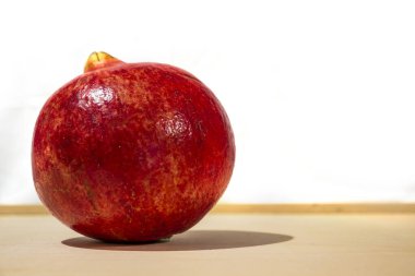 Ahşap zeminde kış meyvesi. Kırmızı nar. Noel ve kış tatilleri. Yakın çekim ve beyaz arkaplan.