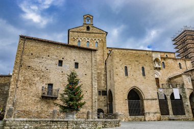Katedral yakınlarındaki ortaçağ köyü Anagni 'de renkli toplar, çiçekler ve çelenkler, kırmızı yıldızlar ve ışıklarla süslenmiş büyük bir Noel ağacı. Roma, Lazio, İtalya.