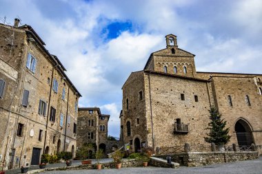 Katedral yakınlarındaki ortaçağ köyü Anagni 'de renkli toplar, çiçekler ve çelenkler, kırmızı yıldızlar ve ışıklarla süslenmiş büyük bir Noel ağacı. Roma, Lazio, İtalya.