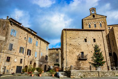 Katedral yakınlarındaki ortaçağ köyü Anagni 'de renkli toplar, çiçekler ve çelenkler, kırmızı yıldızlar ve ışıklarla süslenmiş büyük bir Noel ağacı. Roma, Lazio, İtalya.