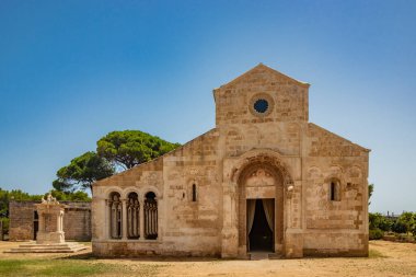 10 Ağustos 2021 - Santa Maria Manastırı a Cerrate, Puglia, Salento, Lecce - Antik Roma Kilisesi, FAI 'nin mirası. Ön cephe, kuyu ve sütunları olan kapıcı. Yazın mavi gökyüzü.