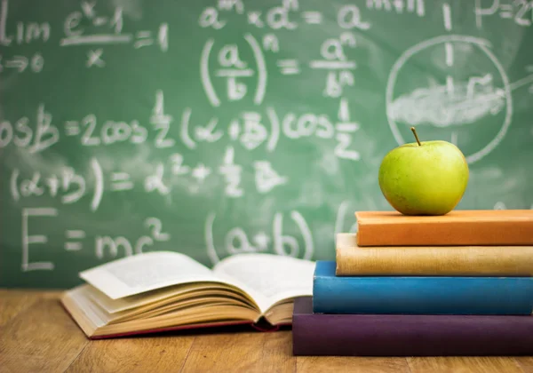 School books with apple on desk — Stock Photo, Image