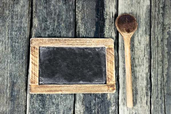 Tafel und Kochlöffel über Holztisch — Stockfoto