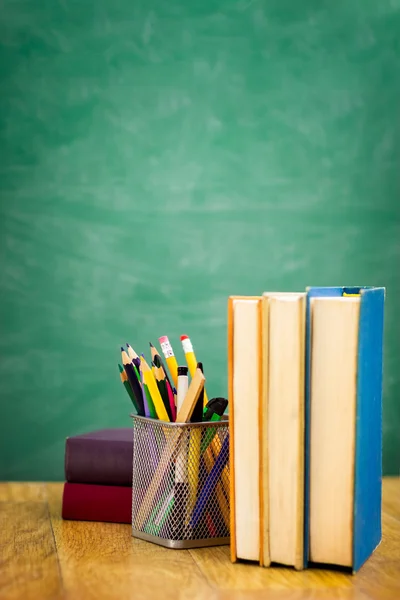 Libros de texto de la escuela en un escritorio frente a la pizarra — Foto de Stock
