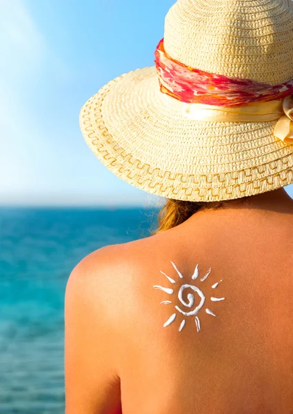 Mujer joven con crema solar en forma de sol — Foto de Stock