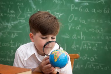 Dünya adlı bir büyüteç aracılığıyla arıyor bir okul çocuğu