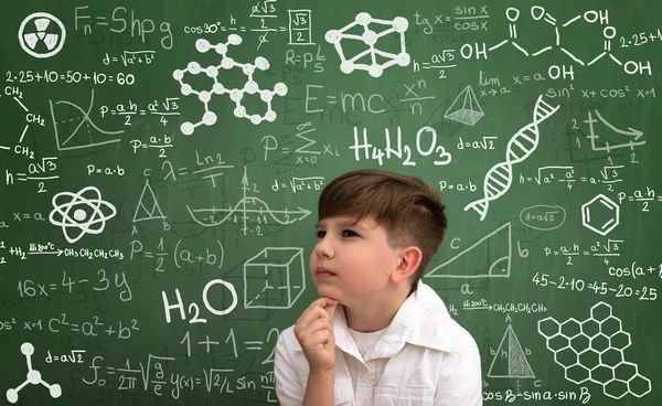 思维与数学公式的小男孩 免版税图库照片