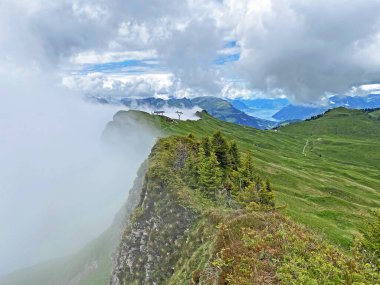 Miraculous low clouds and a mystical fog of the mountain range First and in the Schwyz Alps mountain massif, Oberiberg - Canton of Schwyz, Switzerland (Kanton Schwyz, Schweiz)