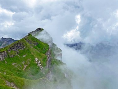 Miraculous low clouds and a mystical fog of the mountain range First and in the Schwyz Alps mountain massif, Oberiberg - Canton of Schwyz, Switzerland (Kanton Schwyz, Schweiz)
