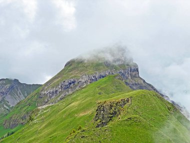 Miraculous low clouds and a mystical fog of the mountain range First and in the Schwyz Alps mountain massif, Oberiberg - Canton of Schwyz, Switzerland (Kanton Schwyz, Schweiz)