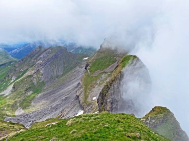 Miraculous low clouds and a mystical fog of the mountain range First and in the Schwyz Alps mountain massif, Oberiberg - Canton of Schwyz, Switzerland (Kanton Schwyz, Schweiz)