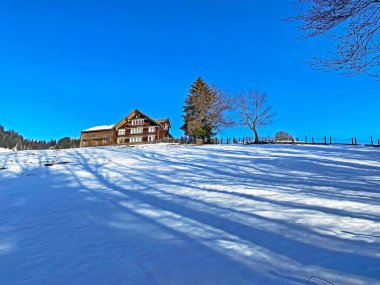 Idyllic Swiss alp dağ kulübeleri ve kışlık giysiler içinde geleneksel İsviçre kırsal mimarisi ve Obertoggenburg bölgesinde yeni bir kar örtüsü, Unterwasser - İsviçre 'nin St. Gallen Kantonu (Schweiz)