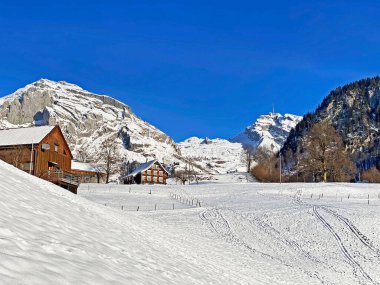 Idyllic Swiss alp dağ kulübeleri ve kışlık giysiler içinde geleneksel İsviçre kırsal mimarisi ve Obertoggenburg bölgesinde yeni bir kar örtüsü, Unterwasser - İsviçre 'nin St. Gallen Kantonu (Schweiz)