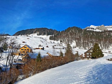 Idyllic Swiss alp dağ kulübeleri ve kışlık giysiler içinde geleneksel İsviçre kırsal mimarisi ve Obertoggenburg bölgesinde yeni bir kar örtüsü, Unterwasser - İsviçre 'nin St. Gallen Kantonu (Schweiz)