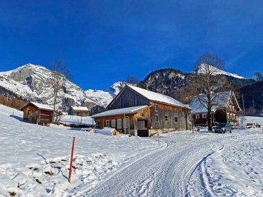 Idyllic Swiss alp dağ kulübeleri ve kışlık giysiler içinde geleneksel İsviçre kırsal mimarisi ve Obertoggenburg bölgesinde yeni bir kar örtüsü, Unterwasser - İsviçre 'nin St. Gallen Kantonu (Schweiz)
