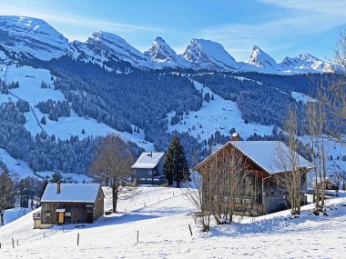 Idyllic Swiss alp dağ kulübeleri ve kışlık giysiler içinde geleneksel İsviçre kırsal mimarisi ve Obertoggenburg bölgesinde yeni bir kar örtüsü, Unterwasser - İsviçre 'nin St. Gallen Kantonu (Schweiz)
