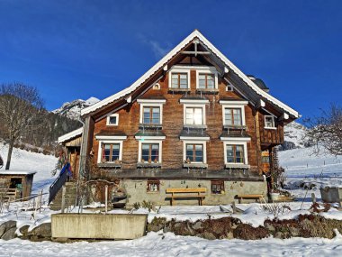 Idyllic Swiss alp dağ kulübeleri ve kışlık giysiler içinde geleneksel İsviçre kırsal mimarisi ve Obertoggenburg bölgesinde yeni bir kar örtüsü, Unterwasser - İsviçre 'nin St. Gallen Kantonu (Schweiz)