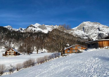 Idyllic Swiss alp dağ kulübeleri ve kışlık giysiler içinde geleneksel İsviçre kırsal mimarisi ve Obertoggenburg bölgesinde yeni bir kar örtüsü, Unterwasser - İsviçre 'nin St. Gallen Kantonu (Schweiz)