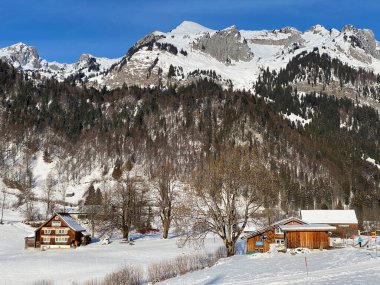 Idyllic Swiss alp dağ kulübeleri ve kışlık giysiler içinde geleneksel İsviçre kırsal mimarisi ve Obertoggenburg bölgesinde yeni bir kar örtüsü, Unterwasser - İsviçre 'nin St. Gallen Kantonu (Schweiz)