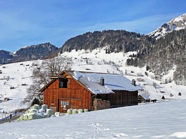 Idyllic Swiss alp dağ kulübeleri ve kışlık giysiler içinde geleneksel İsviçre kırsal mimarisi ve Obertoggenburg bölgesinde yeni bir kar örtüsü, Unterwasser - İsviçre 'nin St. Gallen Kantonu (Schweiz)