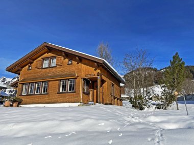 Idyllic Swiss alp dağ kulübeleri ve kışlık giysiler içinde geleneksel İsviçre kırsal mimarisi ve Obertoggenburg bölgesinde yeni bir kar örtüsü, Unterwasser - İsviçre 'nin St. Gallen Kantonu (Schweiz)