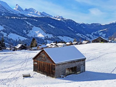 Idyllic Swiss alp dağ kulübeleri ve kışlık giysiler içinde geleneksel İsviçre kırsal mimarisi ve Obertoggenburg bölgesinde yeni bir kar örtüsü, Unterwasser - İsviçre 'nin St. Gallen Kantonu (Schweiz)