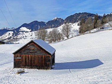 Idyllic Swiss alp dağ kulübeleri ve kışlık giysiler içinde geleneksel İsviçre kırsal mimarisi ve Obertoggenburg bölgesinde yeni bir kar örtüsü, Unterwasser - İsviçre 'nin St. Gallen Kantonu (Schweiz)