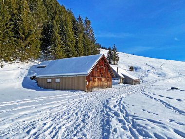 Idyllic Swiss alp dağ kulübeleri ve kışlık giysiler içinde geleneksel İsviçre kırsal mimarisi ve Obertoggenburg bölgesinde yeni bir kar örtüsü, Unterwasser - İsviçre 'nin St. Gallen Kantonu (Schweiz)