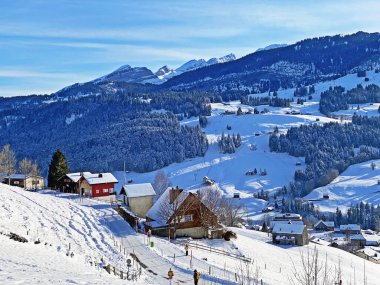 Idyllic Swiss alp dağ kulübeleri ve kışlık giysiler içinde geleneksel İsviçre kırsal mimarisi ve Obertoggenburg bölgesinde yeni bir kar örtüsü, Unterwasser - İsviçre 'nin St. Gallen Kantonu (Schweiz)