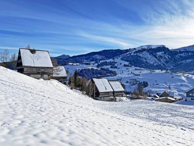 Idyllic Swiss alp dağ kulübeleri ve kışlık giysiler içinde geleneksel İsviçre kırsal mimarisi ve Obertoggenburg bölgesinde yeni bir kar örtüsü, Unterwasser - İsviçre 'nin St. Gallen Kantonu (Schweiz)