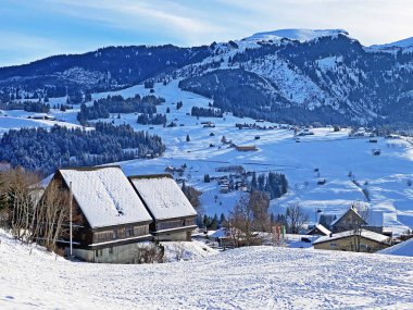 Idyllic Swiss alp dağ kulübeleri ve kışlık giysiler içinde geleneksel İsviçre kırsal mimarisi ve Obertoggenburg bölgesinde yeni bir kar örtüsü, Unterwasser - İsviçre 'nin St. Gallen Kantonu (Schweiz)