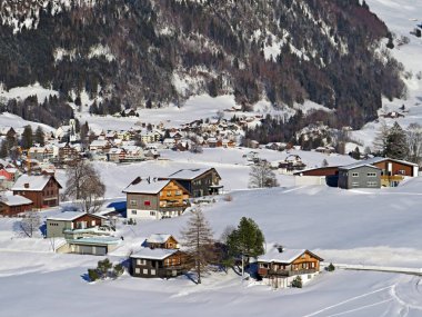 Idyllic Swiss alpine mountain huts and traditional Swiss rural architecture dressed in winter clothes and in a fresh snow cover in the Obertoggenburg region, Wildhaus - Canton of St. Gallen, Switzerland (Schweiz)