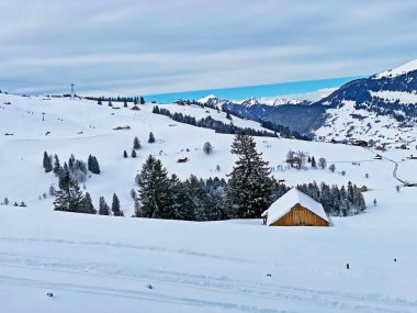 Idyllic Swiss alpine mountain huts and traditional Swiss rural architecture dressed in winter clothes and in a fresh snow cover in the Obertoggenburg region, Wildhaus - Canton of St. Gallen, Switzerland (Schweiz)