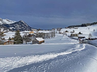 Idyllic Swiss alpine mountain huts and traditional Swiss rural architecture dressed in winter clothes and in a fresh snow cover in the Obertoggenburg region, Wildhaus - Canton of St. Gallen, Switzerland (Schweiz)