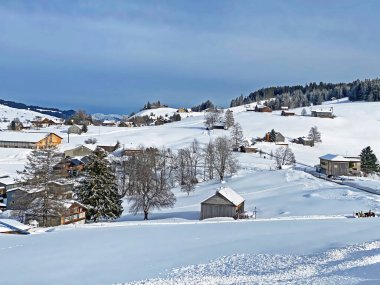 Idyllic Swiss alpine mountain huts and traditional Swiss rural architecture dressed in winter clothes and in a fresh snow cover in the Obertoggenburg region, Wildhaus - Canton of St. Gallen, Switzerland (Schweiz)