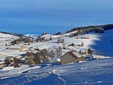 Idyllic Swiss alpine mountain huts and traditional Swiss rural architecture dressed in winter clothes and in a fresh snow cover in the Obertoggenburg region, Wildhaus - Canton of St. Gallen, Switzerland (Schweiz)