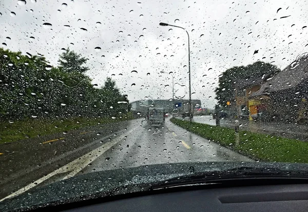 Raindrops on car glass with city silhouettes in the background out of focus - St. Gallen, Switzerland (Schweiz)