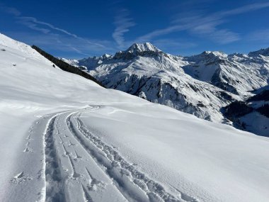 İsviçre Alpleri ve St. Antonien (Kanton Graubuenden, Schweiz) Kantonu üzerindeki St. Antoenien köyünün taze dağlık kar örtüsü üzerinde harika kış yürüyüş yolları ve izler vardır.)