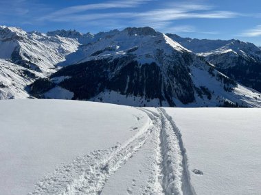 İsviçre Alpleri ve St. Antonien (Kanton Graubuenden, Schweiz) Kantonu üzerindeki St. Antoenien köyünün taze dağlık kar örtüsü üzerinde harika kış yürüyüş yolları ve izler vardır.)