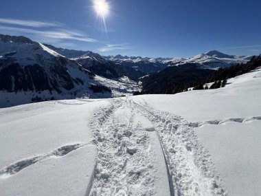 İsviçre Alpleri ve St. Antonien (Kanton Graubuenden, Schweiz) Kantonu üzerindeki St. Antoenien köyünün taze dağlık kar örtüsü üzerinde harika kış yürüyüş yolları ve izler vardır.)