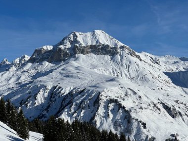 İsviçre köyü ve St. Antonien (St. Antoenien) 'in (Kanton Graubuenden, Schweiz) üzerinde güneşli ve karla kaplı güzel tepeler (Kanton Graubuenden, İsviçre))