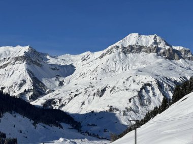 İsviçre köyü ve St. Antonien (St. Antoenien) 'in (Kanton Graubuenden, Schweiz) üzerinde güneşli ve karla kaplı güzel tepeler (Kanton Graubuenden, İsviçre))