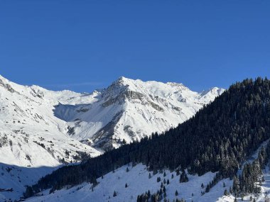 İsviçre köyü ve St. Antonien (St. Antoenien) 'in (Kanton Graubuenden, Schweiz) üzerinde güneşli ve karla kaplı güzel tepeler (Kanton Graubuenden, İsviçre))