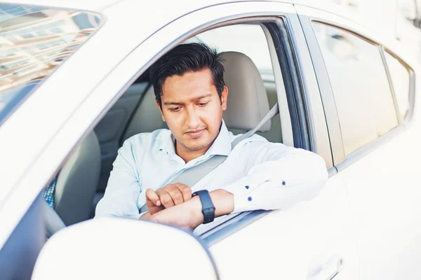 Młody Indianin Patrząc Inteligentny Zegarek Siedząc Samochodzie Obrazek Stockowy